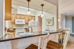 een keuken met een aanrecht met stoelen en een wastafel bij Treetops 7003 in Hilton Head Island