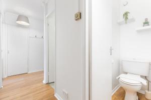 baño con paredes blancas y aseo en The Bermondsey Apartments en Londres