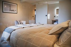 a large bed with pillows on it in a room at Mas d images styled by Scapa Home in Arles