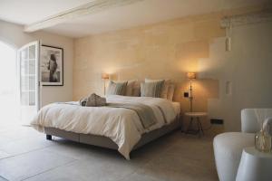 a bedroom with a large bed and a chair at Mas d images styled by Scapa Home in Arles