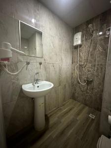 een badkamer met een wastafel en een douche bij DİAMOND PALACE APART HOTEL in Hatay