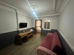 a living room with a couch and a television at DİAMOND PALACE APART HOTEL in Hatay