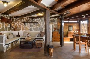 una sala de estar con una pared de piedra en Casa Kesa, el Rincon de Juan, en Tías