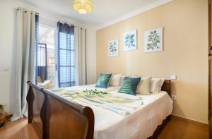 Un dormitorio con una gran cama blanca con almohadas azules. en Casa Kesa, el Rincon de Juan, en Tías 30 fotos más