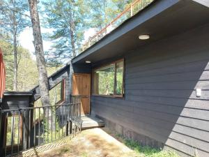 a black house with a porch and a balcony at Cabaña Rocario Termas de Chillan in Las Trancas