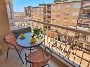 a table and chairs on a balcony with a view of a city at Playa de Poniente con Aire Acondicionado, Parking y Wifi - by Aloha Palma in Águilas