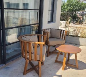聖伊西德羅的住宿－La Belle San Isidro Lofts - Loft Violetas，门廊上配有两把椅子和一张茶几