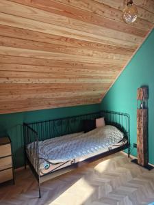 Łóżko w pokoju z drewnianym sufitem w obiekcie Domek pod Jagodną 824 m n.p.m. Spalona 6 BE w mieście Spalona