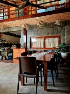 - une salle à manger avec une table et des chaises en bois dans l'établissement El Lobo Hostel, à General Luna