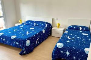 sypialnia z 2 łóżkami i niebieską kołdrą w obiekcie I TREPPONTI w mieście Comacchio