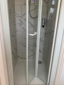 a shower with a glass door in a bathroom at Preto in Croydon