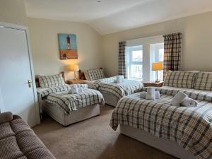 a living room with three beds and a couch at Princetown Guesthouse in Bangor