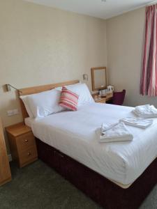 una habitación de hotel con una cama grande con toallas. en Metropole Hotel, en Torquay