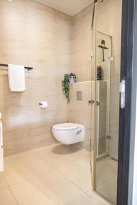 een badkamer met een toilet en een glazen douche bij Blue Bay Resort luxury apartment Palm View in Blauw Baai