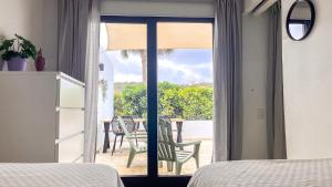 a bedroom with a door open to a patio with a table at Blue Bay Resort luxury apartment Palm View in Blue Bay