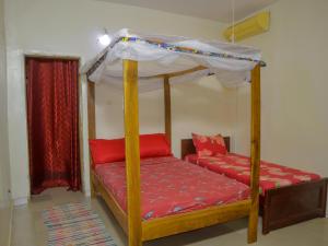 a bedroom with a bed with a canopy at La Case a Mamy in Nianing