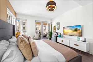 een slaapkamer met een groot bed en een televisie aan de muur bij Luxuri Suites 310 in Miami Beach in Miami Beach