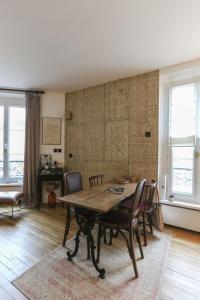 a dining room with a wooden table and chairs at Pretty nest near Canal St Martin in Paris