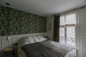 a bedroom with a bed and a window at Pretty nest near Canal St Martin in Paris