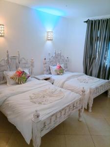 2 camas blancas en una habitación con en Lux Suites Lamera Beachfront Apartments, en Shanzu