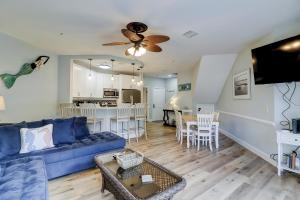 Il comprend un salon avec un canapé bleu et une cuisine. dans l'établissement Ocean Breeze 27, à Île de Hilton-Head