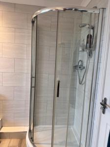 a shower with a glass door in a bathroom at Halekulani Devon Homestay in Torquay