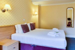 Una habitación de hotel con una cama con toallas. en Queens Hotel, en Blackpool
