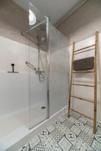 une douche avec une porte vitrée dans une salle de bain dans l'établissement L'Eugène - Maison 3 chambres, à Vichy 37 autres photos