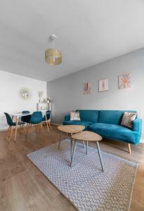 a living room with a blue couch and a table at L'Eugène - Maison 3 chambres in Vichy