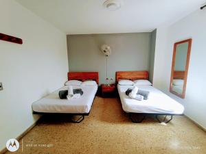 two twin beds in a room with a mirror at Hotel Medellin Kapital in Medellín