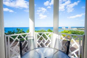 a balcony with two chairs and a view of the ocean at Ocho Rios Ocean Front Luxury Studio Sky Castles 24 hrs sleeps 2 in Ocho Rios
