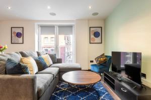 een woonkamer met een bank, een tafel en een tv bij Smart 1 Bed Apartment in Central Hull in Hull
