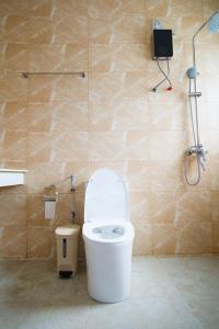 een badkamer met een wit toilet en een douche bij Coco Villa Ukulhas in Ukulhas