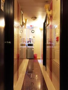 a hallway leading to a kitchen with a refrigerator at Germany Hostel Block D in Hong Kong