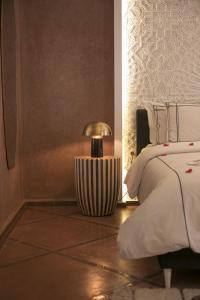 1 dormitorio con 1 cama y 1 lámpara en el suelo en Riad Chamali, en Marrakech
