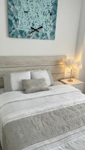 una camera con un letto bianco e una foto appesa al muro di Madrid House Boutique , Aeropuerto , Ifema a Madrid