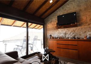 sala de estar con TV de pantalla plana en la pared en MyStay - O Palheiro en Caramulo