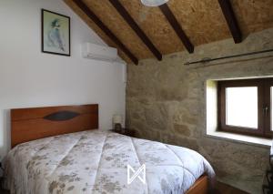 a bedroom with a bed in a room with a window at MyStay - O Palheiro in Caramulo