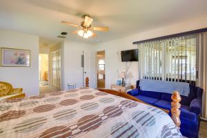 a bedroom with a bed and a blue couch at Walk to Lake Home with Screened Porch in Sebring! in Sebring