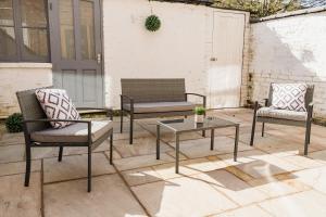 three chairs and a coffee table on a patio at Lovely 3 bedroom home in Hoole, Chester - Perfect for families in Chester