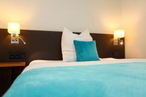 ein Schlafzimmer mit einem großen Bett mit blauen und weißen Kissen in der Unterkunft Sportschule Wedau in Duisburg