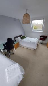 a room with two beds and a chair and a window at Unique house with up to 3 self contained living areas in Bournemouth