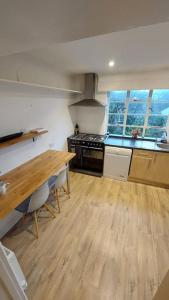 a kitchen with a wooden table and a wooden floor at Unique house with up to 3 self contained living areas in Bournemouth