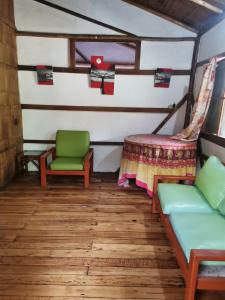 sala de estar con sofá y silla en Cabañas Bambu Mindo, en Mindo