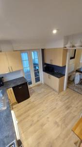 an empty room with a kitchen with wooden floors at Unique house with up to 3 self contained living areas in Bournemouth