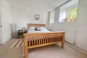 a bedroom with a wooden bed and a window at Unique house with up to 3 self contained living areas in Bournemouth