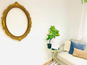 a mirror and a couch with a potted plant at Moderno Apartamento cerca del metro in Bilbao