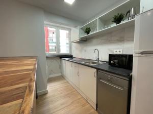 a kitchen with a sink and a microwave at Moderno Apartamento cerca del metro in Bilbao