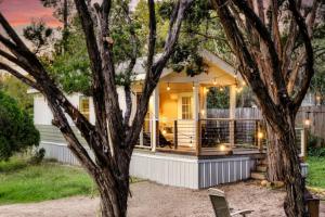 a house with a porch with a tree at Lone Star Tiny Home - 15 minutes to downtown in Austin