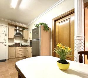 eine Küche mit einem Kühlschrank und einem Tisch mit einer Vase aus Blumen in der Unterkunft Tranquilo apartamento cerca del Casco Viejo Bilbao in Bilbao